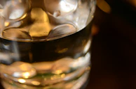 Close-up of a gold-rimmed glass with gentle light highlighting its curves.