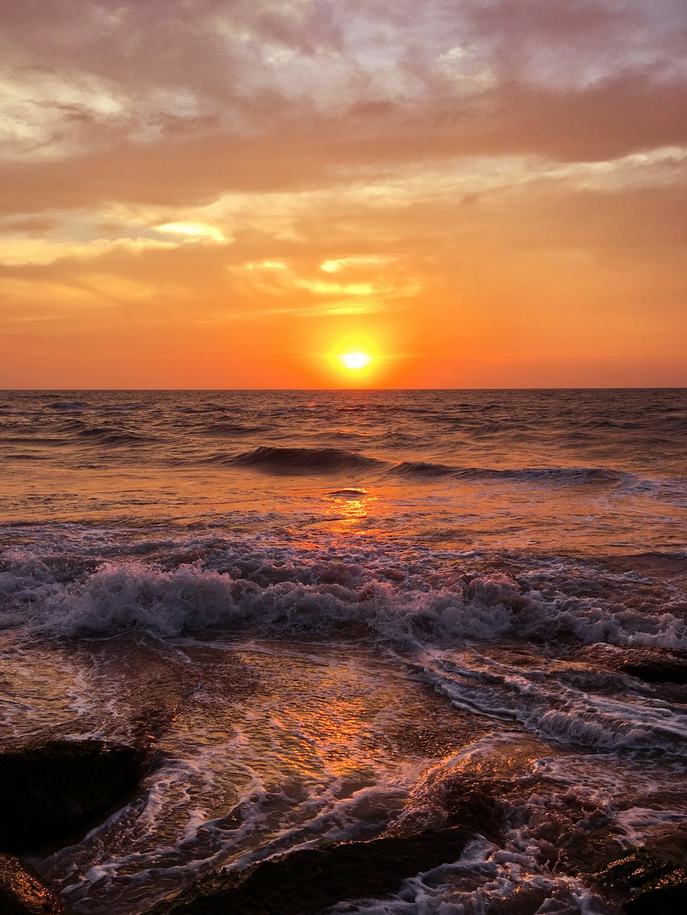 Mar calmo com vista para o pôr do sol