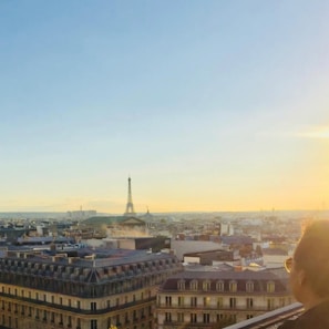 A stunning view of the Eiffel Tower at sunset with warm golden light illuminating the Paris skyline.