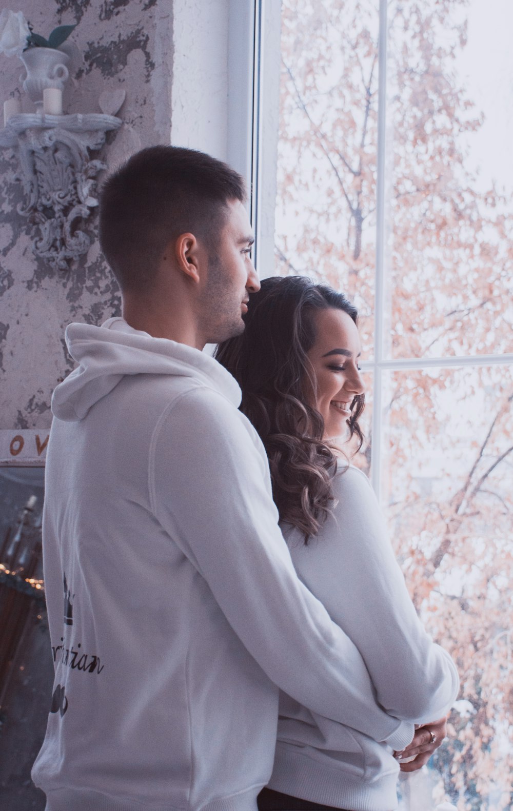 couple hugging facing window on focus photography