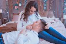 man and woman sitting on bed