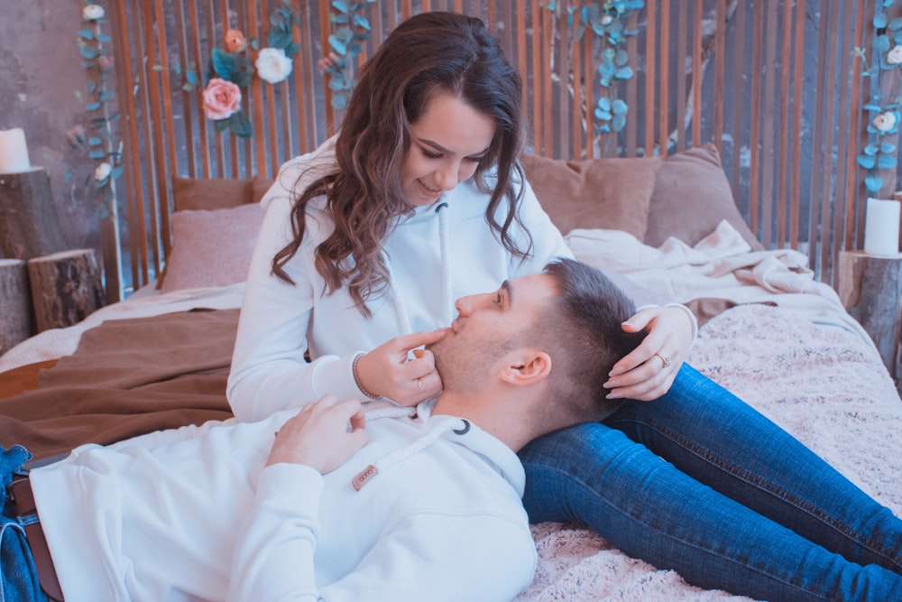 man and woman sitting on bed