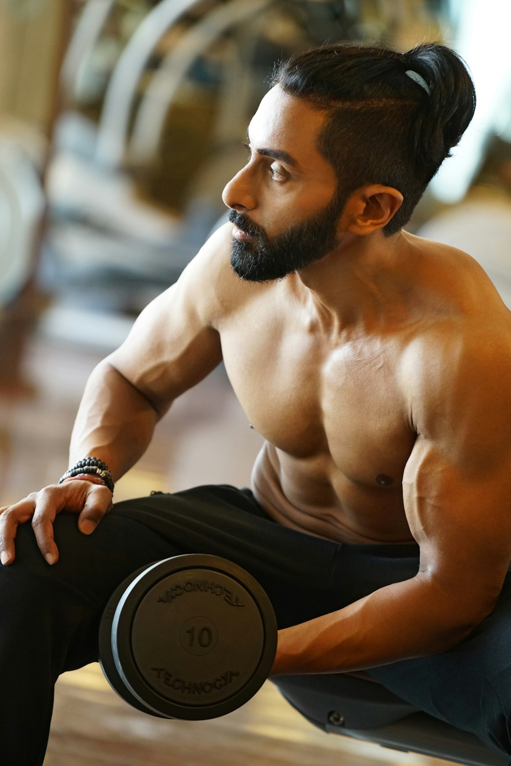 topless man holding dumbbell