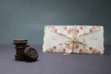Elegant packaging featuring custom sugar cookies nestled in cream-colored boxes with soft shadows.