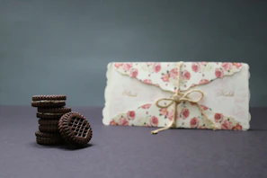 Elegant packaging featuring custom sugar cookies nestled in cream-colored boxes with soft shadows.