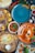 A variety of dishes presented on colorful plates, including a soup with herbs, flatbreads with toppings, and an assortment of vegetables. The vibrant arrangement of food is complemented by condiments such as sauces and spices scattered around.