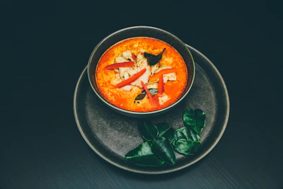 Elegant plating of Singapore laksa with vibrant herbs and spices.