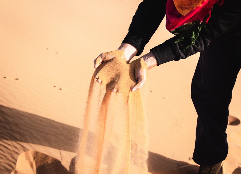 person pouring sand