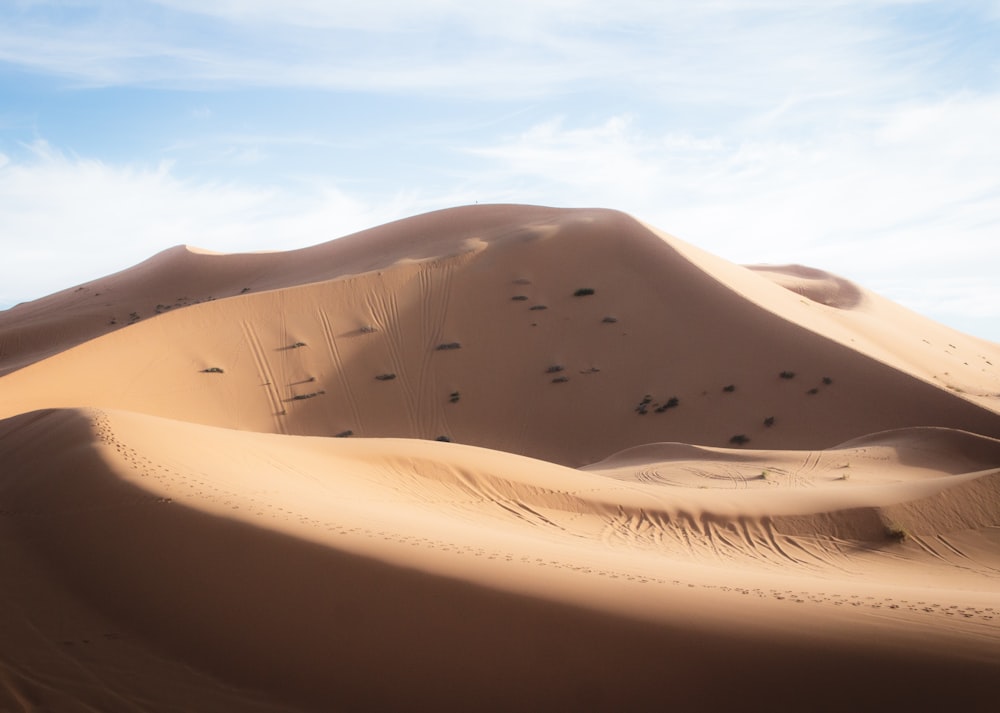brown sand dunes under white and blue sky