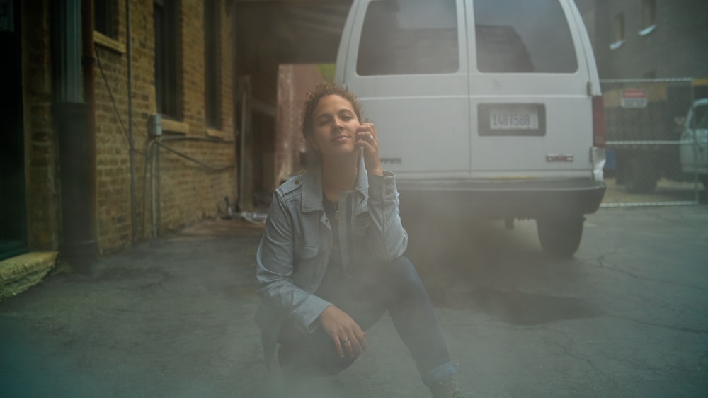 woman kneeling on ground beside car