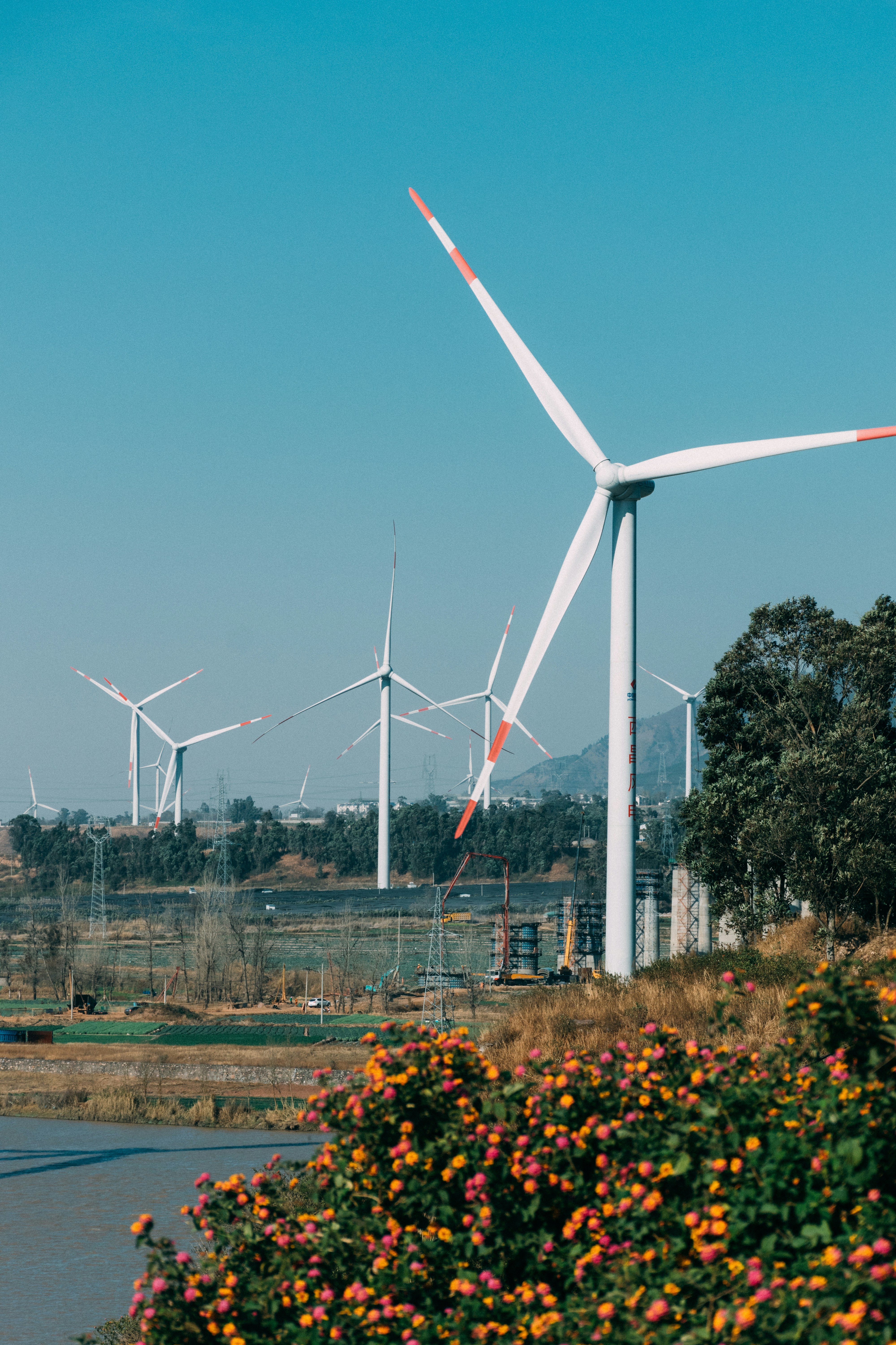 Bright wind turbines against clear blue sky, open landscape, natural daylight