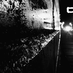 Close-up of a smooth, glossy wall surface treated with Aqua-Shield, reflecting light under industrial lighting.