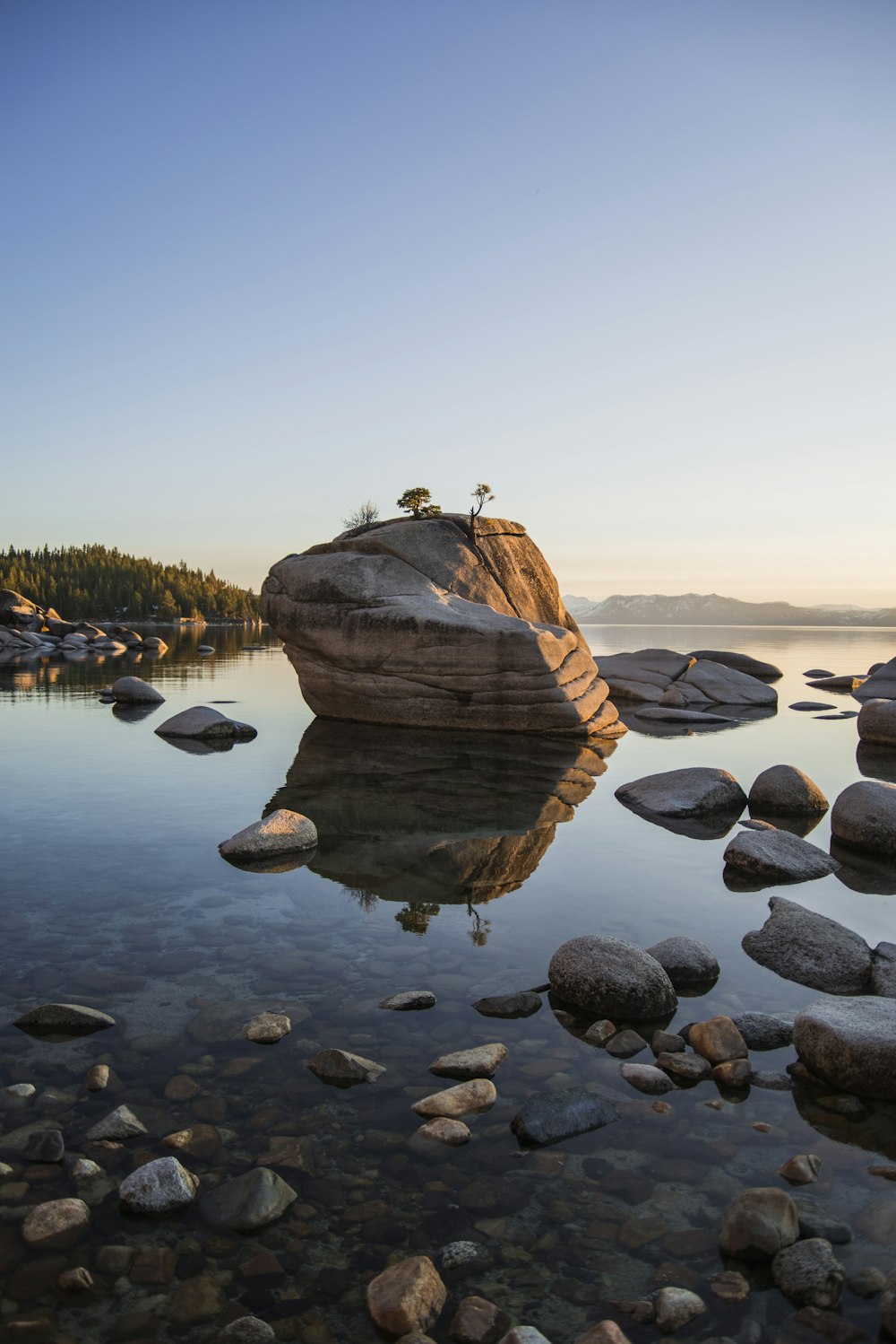 rock on lake under calming sky