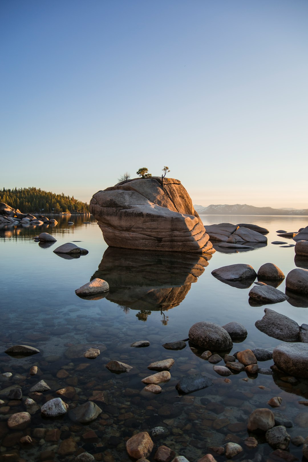 rock on lake under calming sky