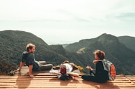 three people overlooking mountains