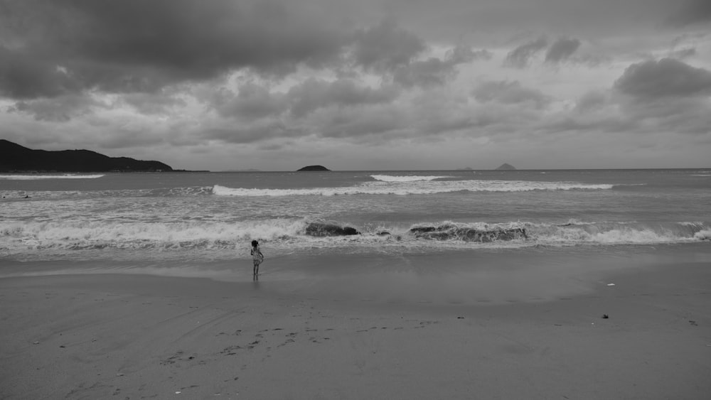 grayscale photo of man on shore