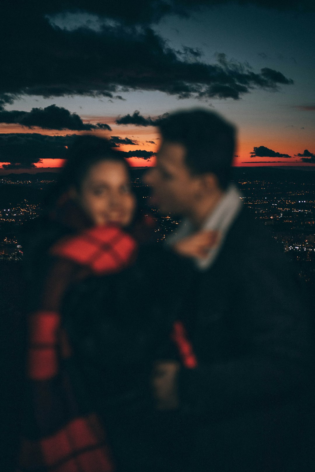 man and woman standing on mountain during nighttime