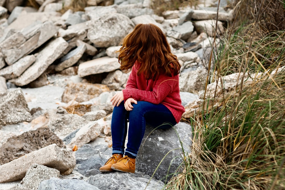 woman sitting on rock