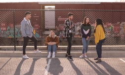 five persons on front of chain link fence