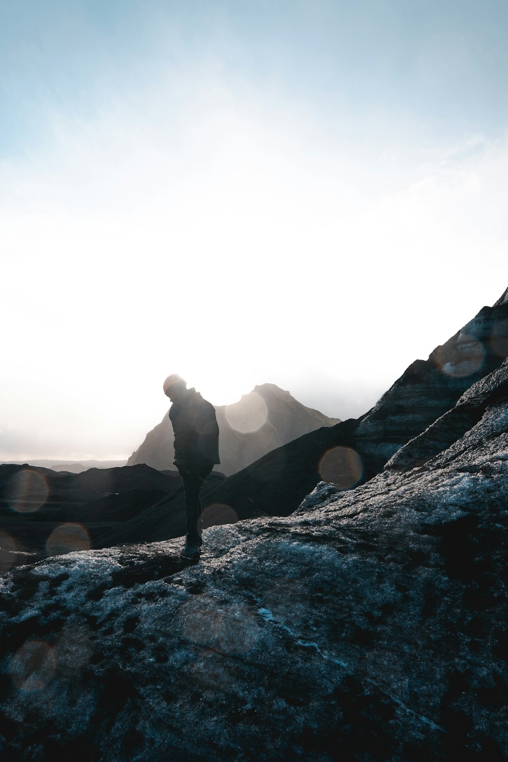 silhouette of man standing on stone mountain