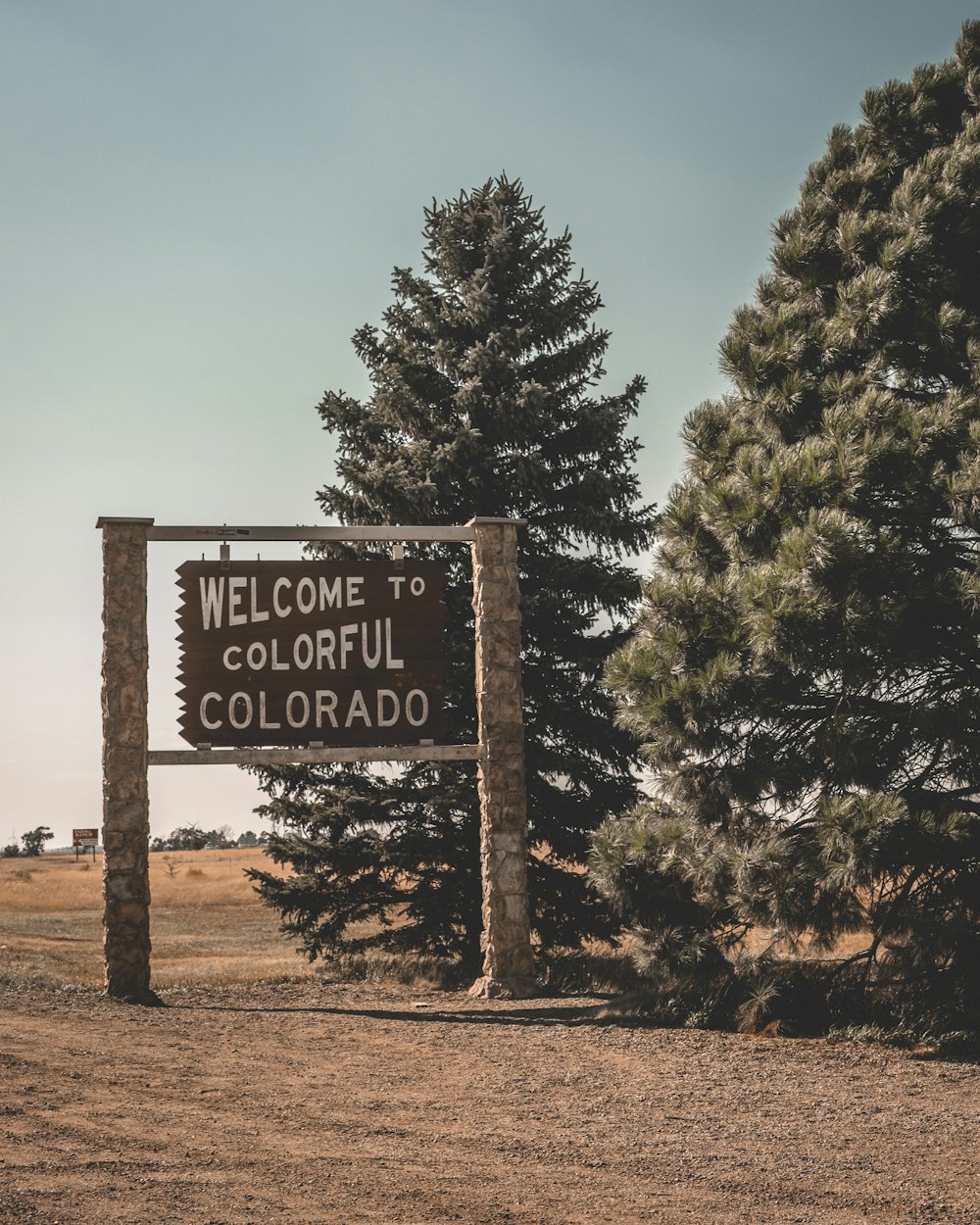 welcome to colorful Colorado signage beside trees