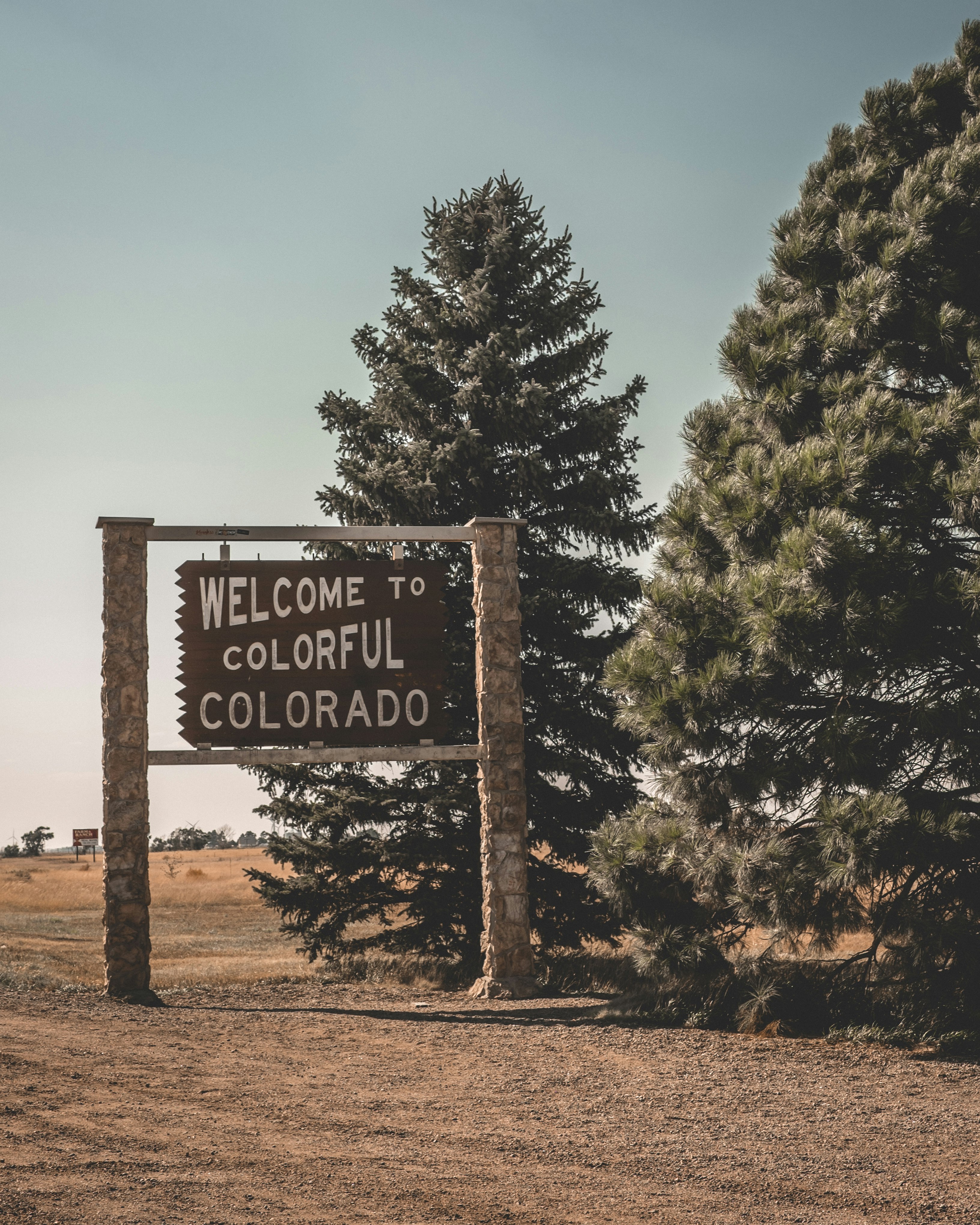 welcome to colorful Colorado signage beside trees