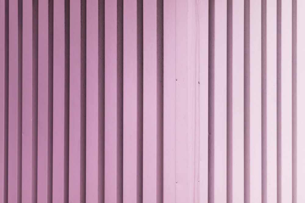 a close up of a purple wall with vertical lines
