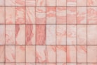 a close up of a pink marble tile wall