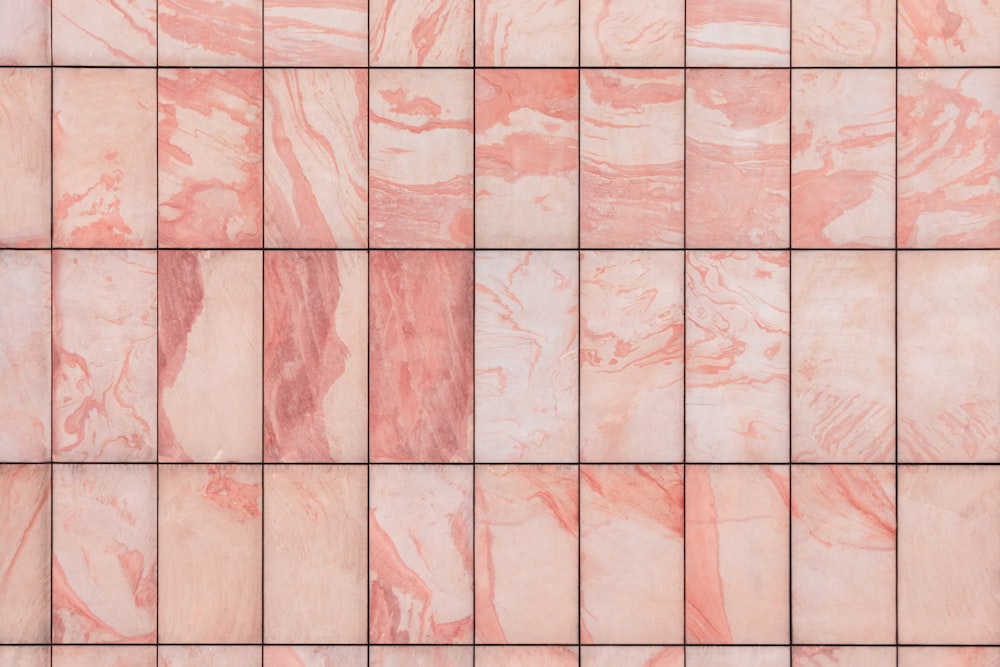 a close up of a pink marble tile wall