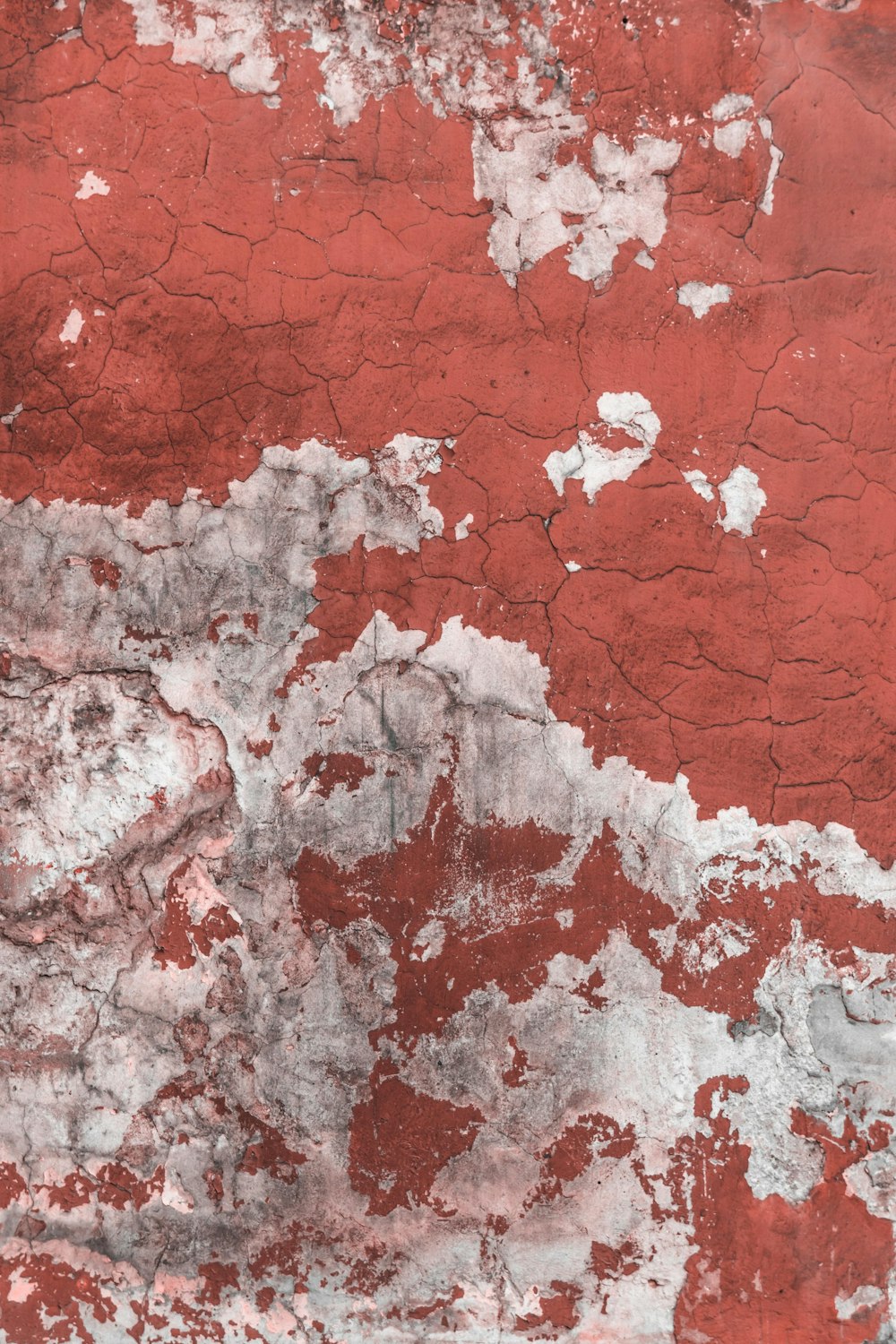a red and white wall with peeling paint