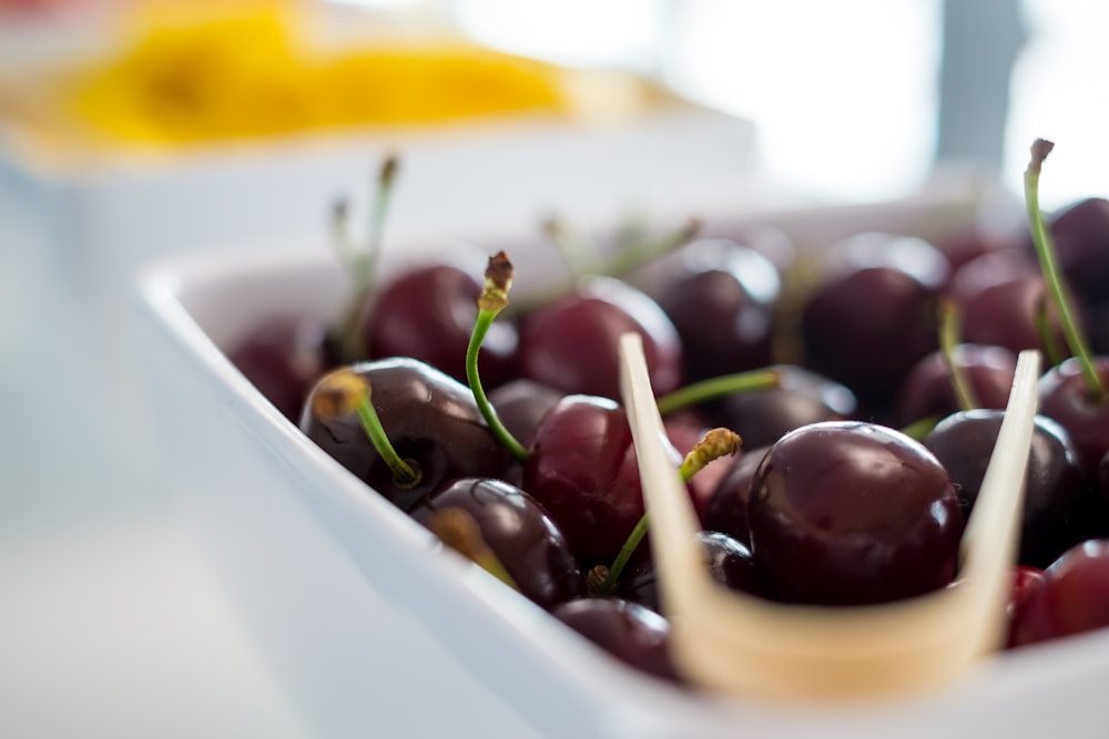 red cherries in white ceramic bowl