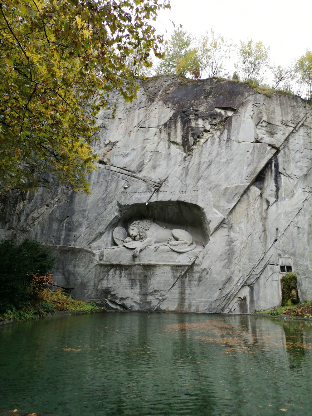 grey lion statue on rocky mountain during daytime