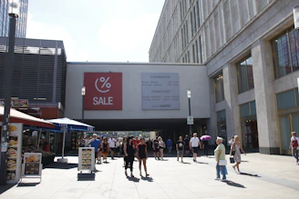 A bustling commercial plaza with shops and people walking.