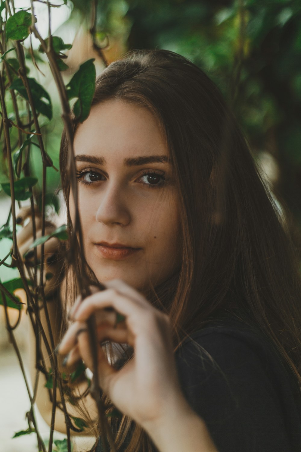 selective focus photography of woman touching leafed vines