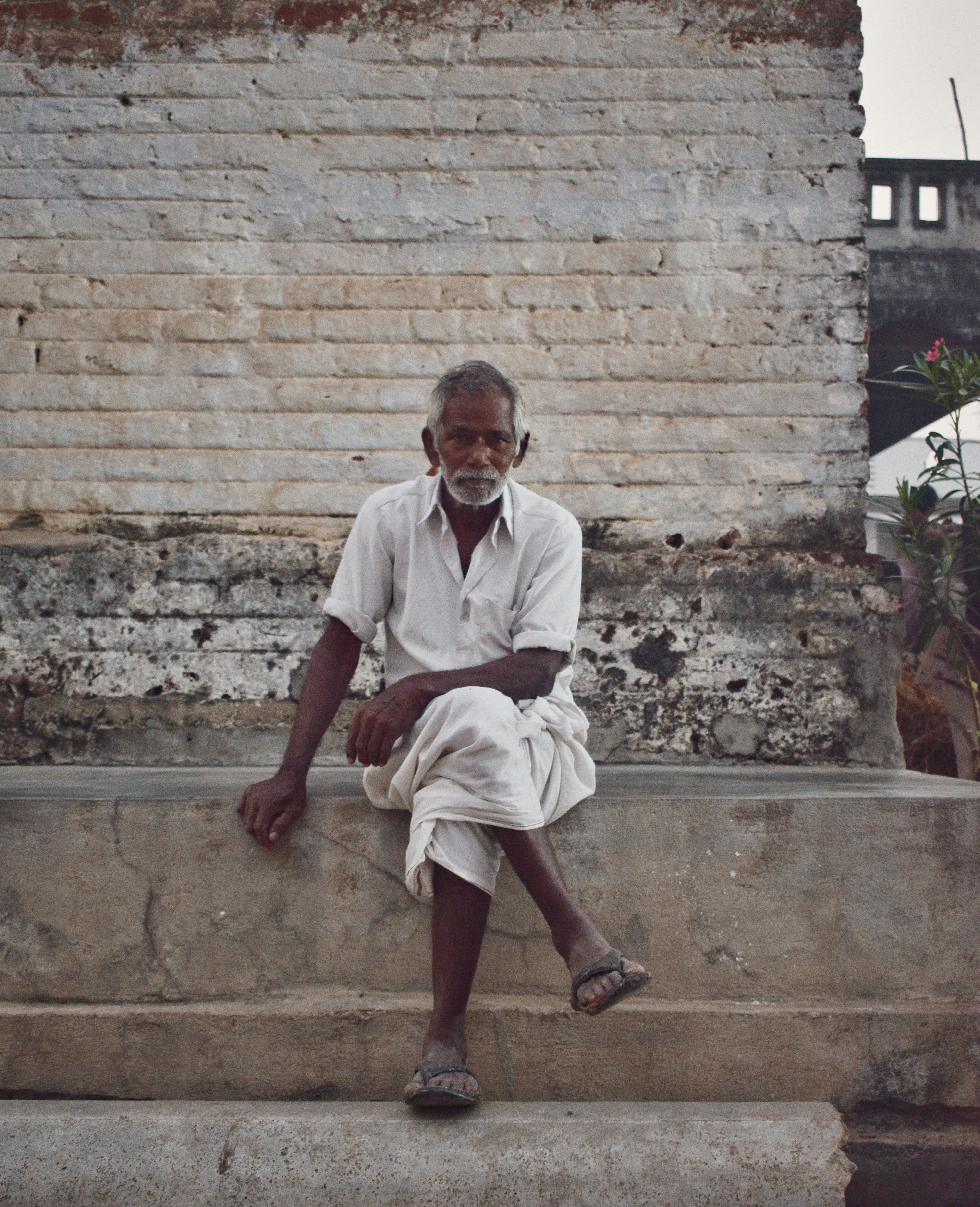 家の近くにあぐらをかいて座っている男の写真 Unsplashで見つけるグレーの無料写真