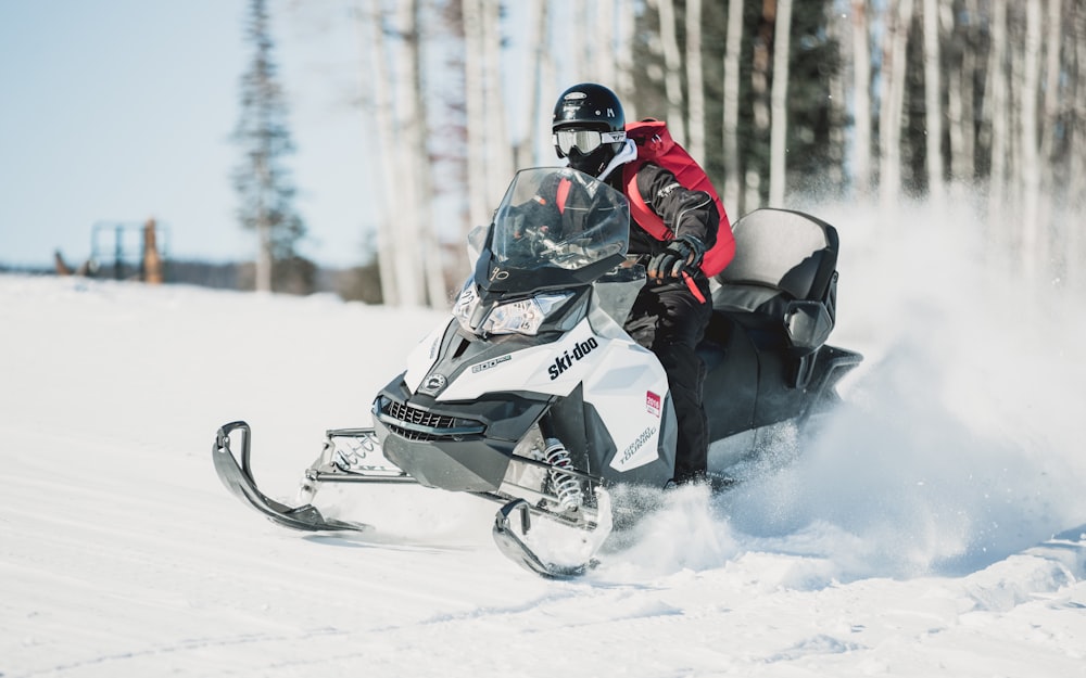 Persona que monta una moto de nieve durante el día