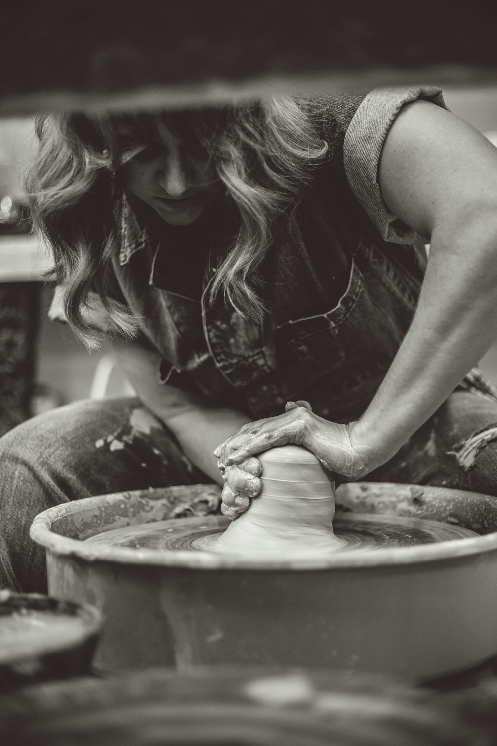 woman molding clay pot greyscale photography