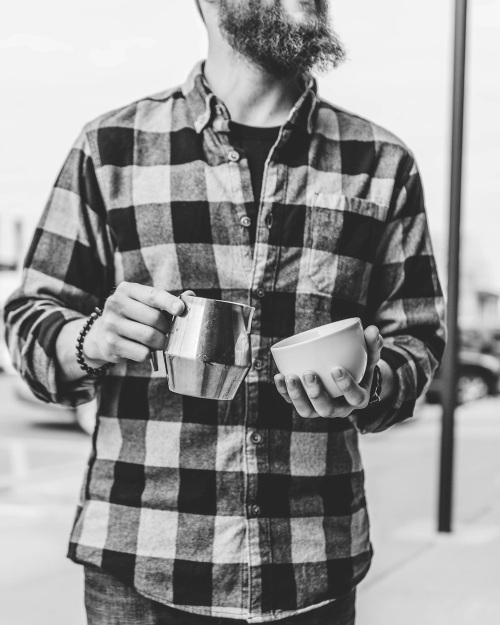 grayscale photo of man holding mugs