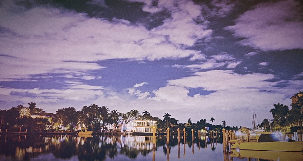 selective focus photography calm body of water near white concrete house