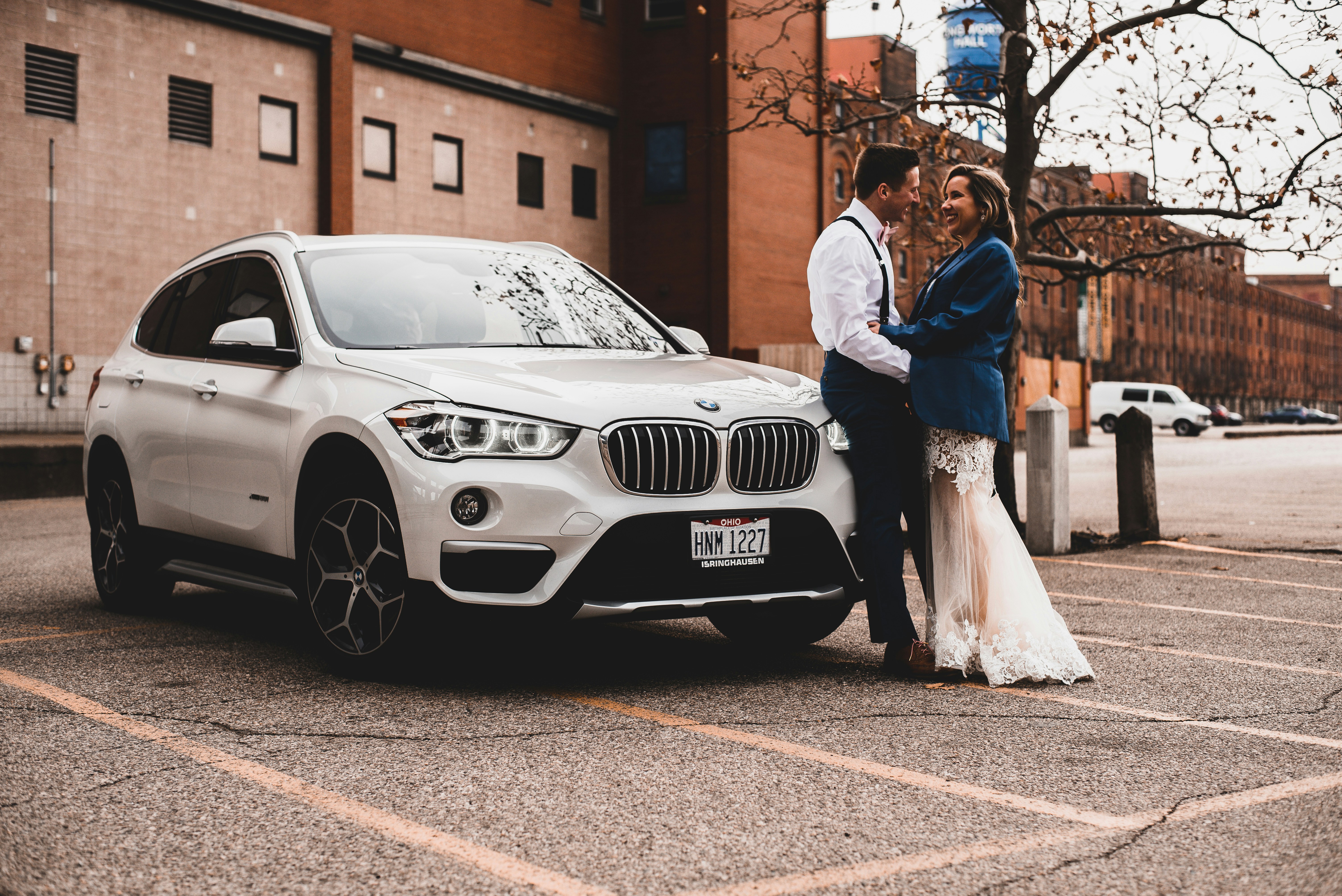 Smiling couple reviewing paperwork with a salesperson while buying a used car