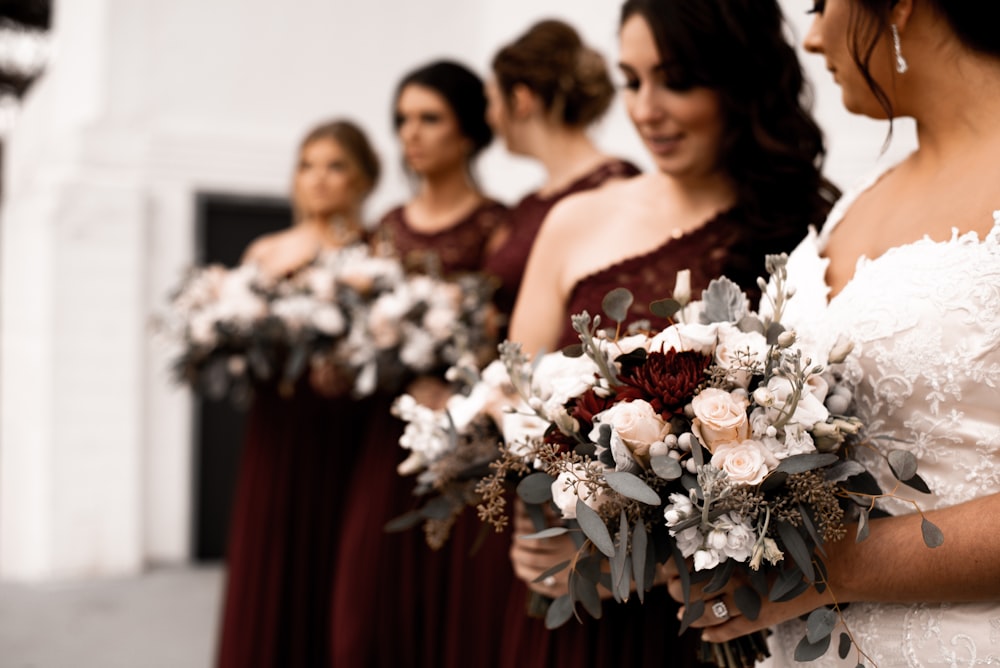 shallow focus photo of woman holding white flowers