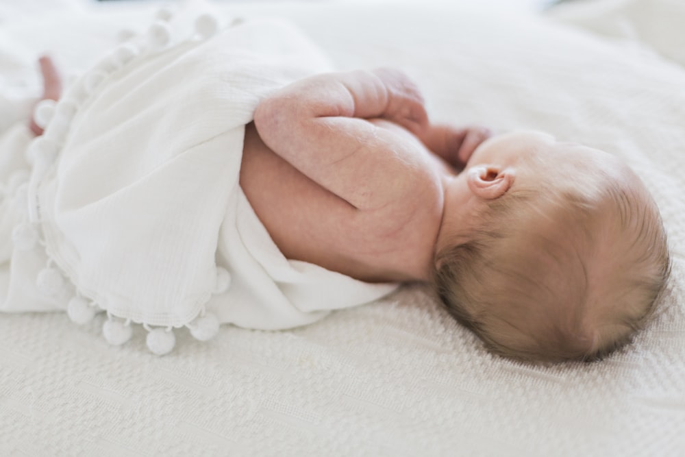 sleeping baby covered in white cloth