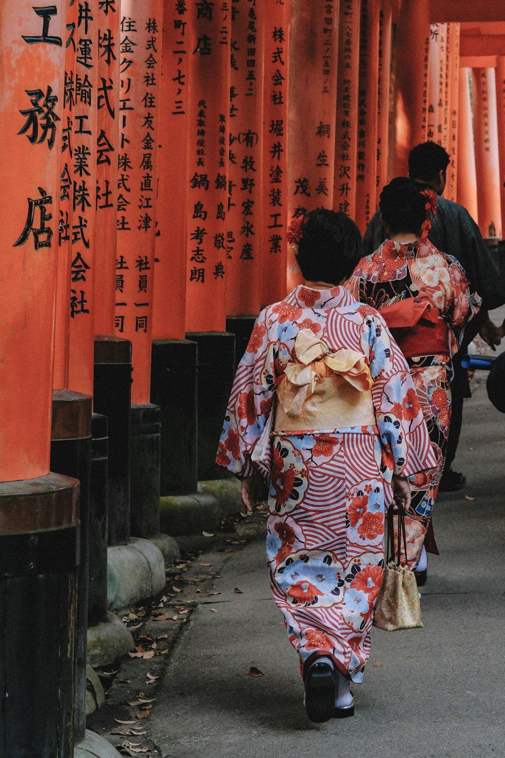 woman in red and blue floral long-sleeved dress walking on streets