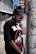 A woman rocking a graphic tee from 'grew in da struggle' with urban graffiti in the background.