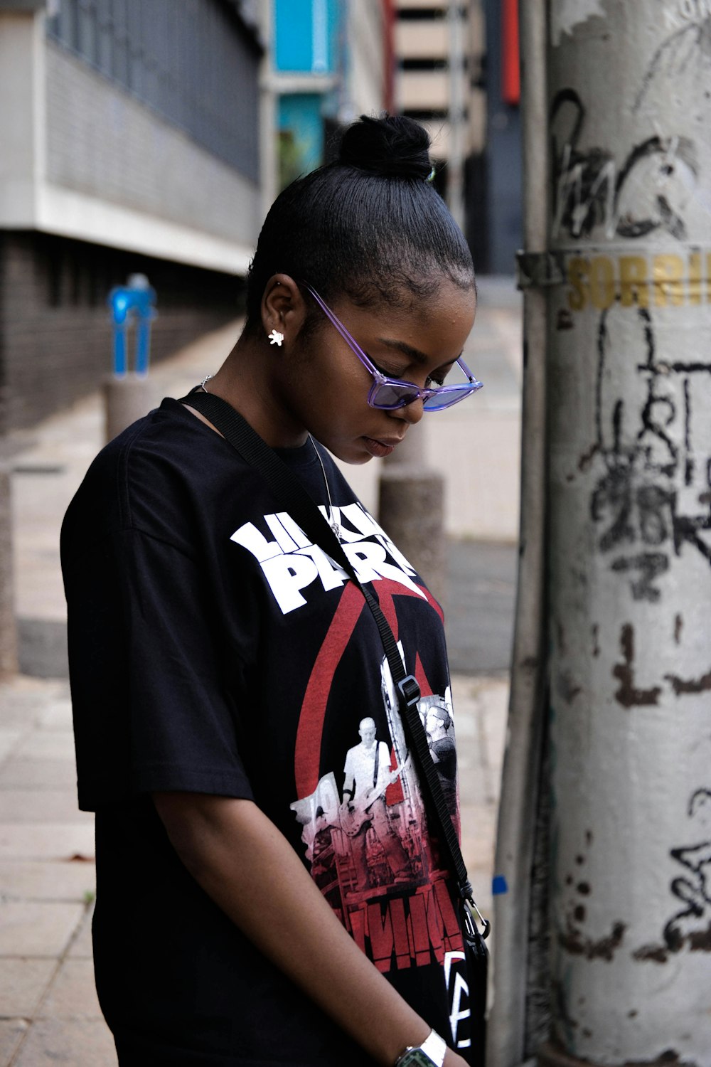 woman wearing black t-shirt standing near concrete post