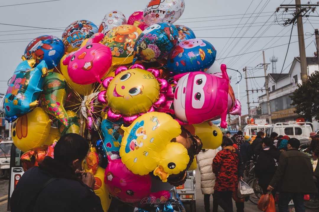 man holding assorted balloons