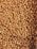Close-up of neatly stacked palm kernel shells in a warehouse setting.