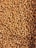 Close-up of neatly stacked palm kernel shells in a warehouse setting.