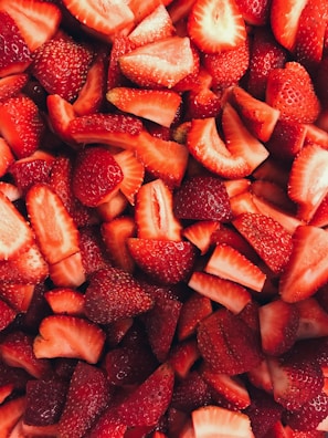 Close-up of colorful freeze-dried strawberry slices arranged on a wooden board.