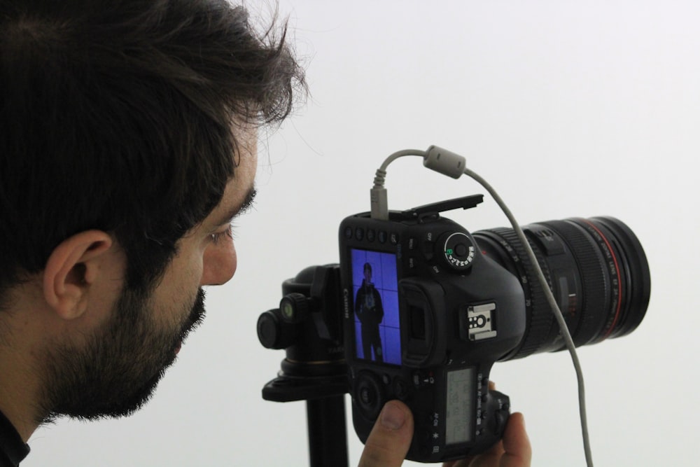 man using black DSLR camera